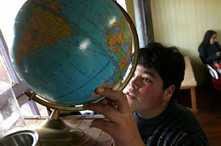 Javier y sus compañeros usan el globo terráqueo del colegio para responder a preguntas sobre geografía y sobre los cambios del mundo." title="Javier y sus compañeros usan el globo terráqueo del colegio para responder a preguntas sobre geografía y sobre los cambios del mundo.